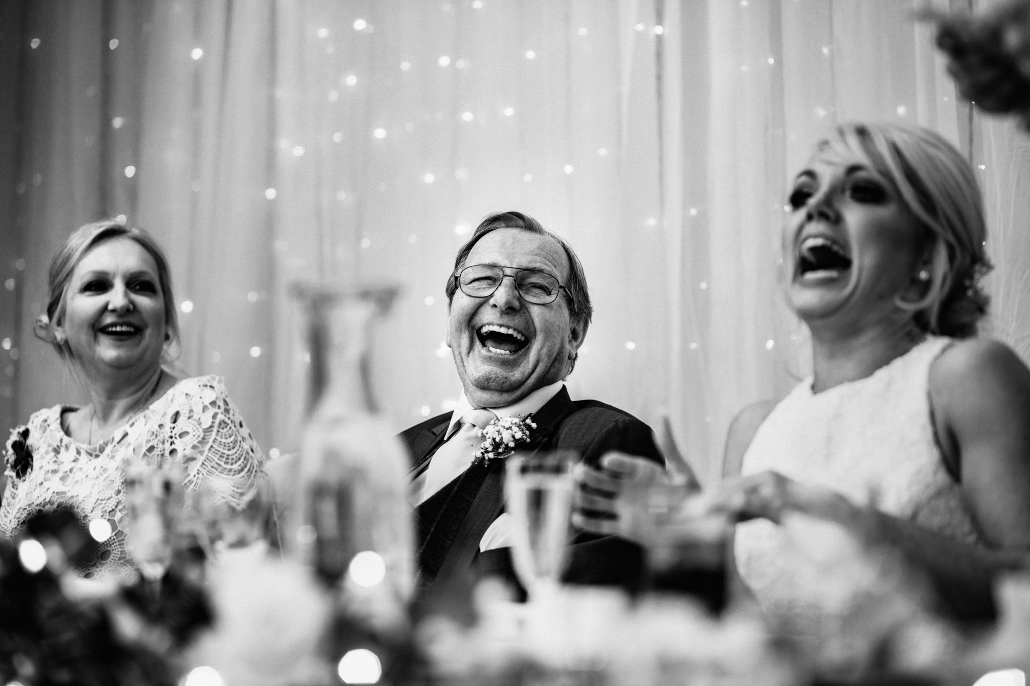 Father of the bride laughing during speeches