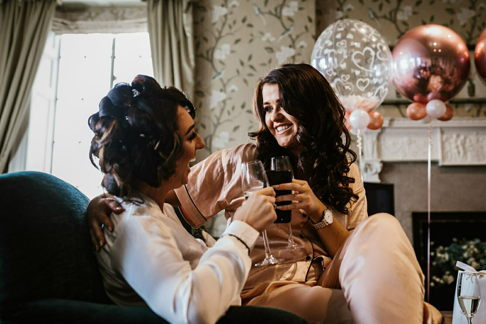 Bride sat laughing with her bridesmaid